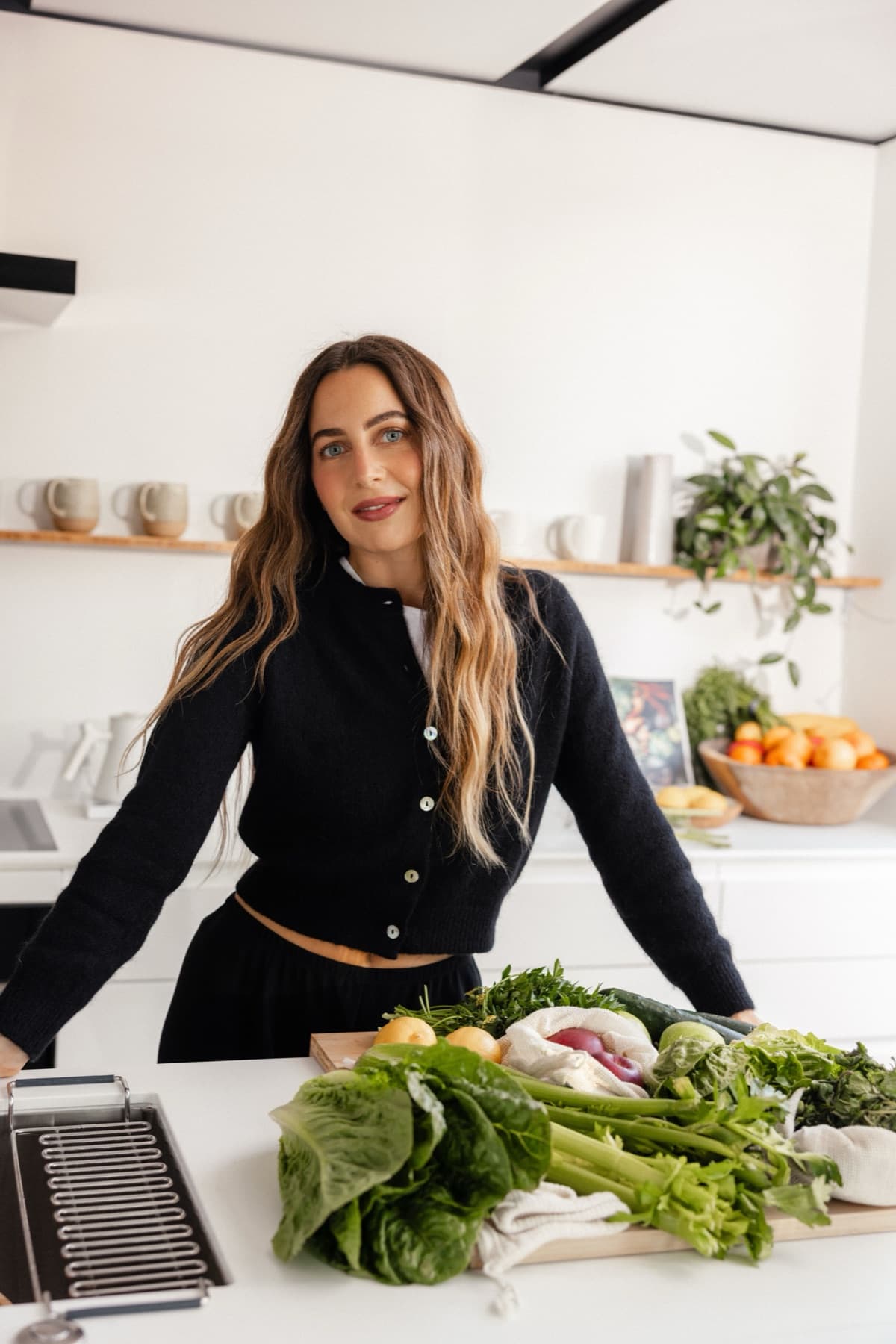 Meghan Swidler standing at a kitchen counter behind a tray of fresh vegetables